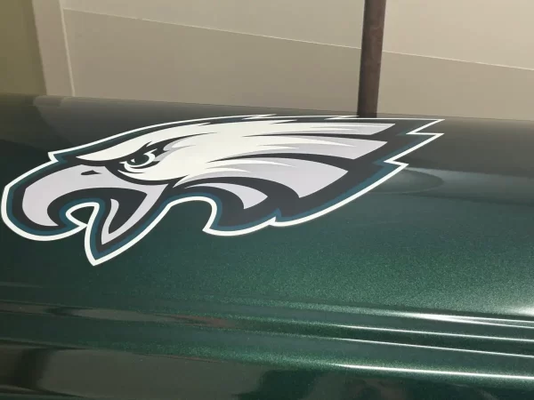 Black and silver casket with a glossy finish and silver panel detailing, displayed closed on a wheeled stand in a showroom setting