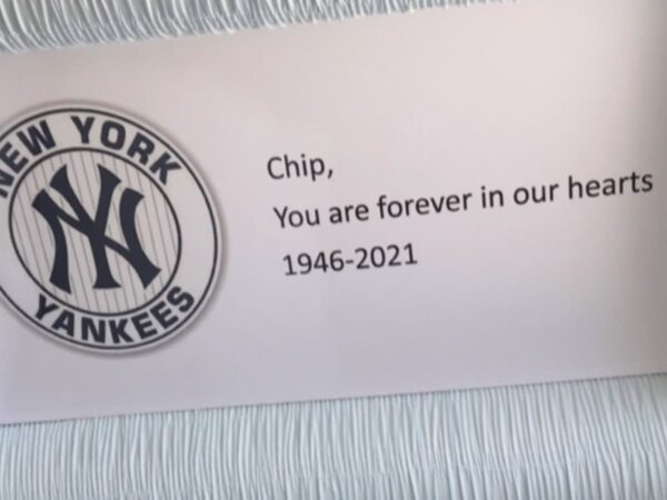Plaque with the New York Yankees logo and a tribute message: "Chip, You are forever in our hearts 1946-2021," conveying remembrance and nostalgia.
